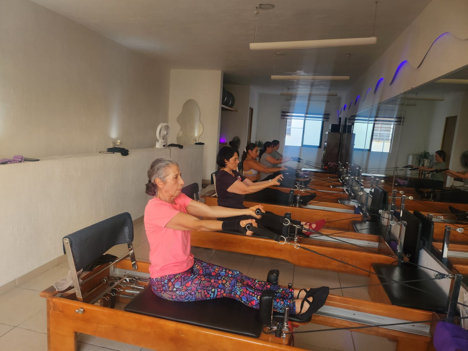 Una alumna de Sport Pilates ejercitándose en reformer junto a su grupo